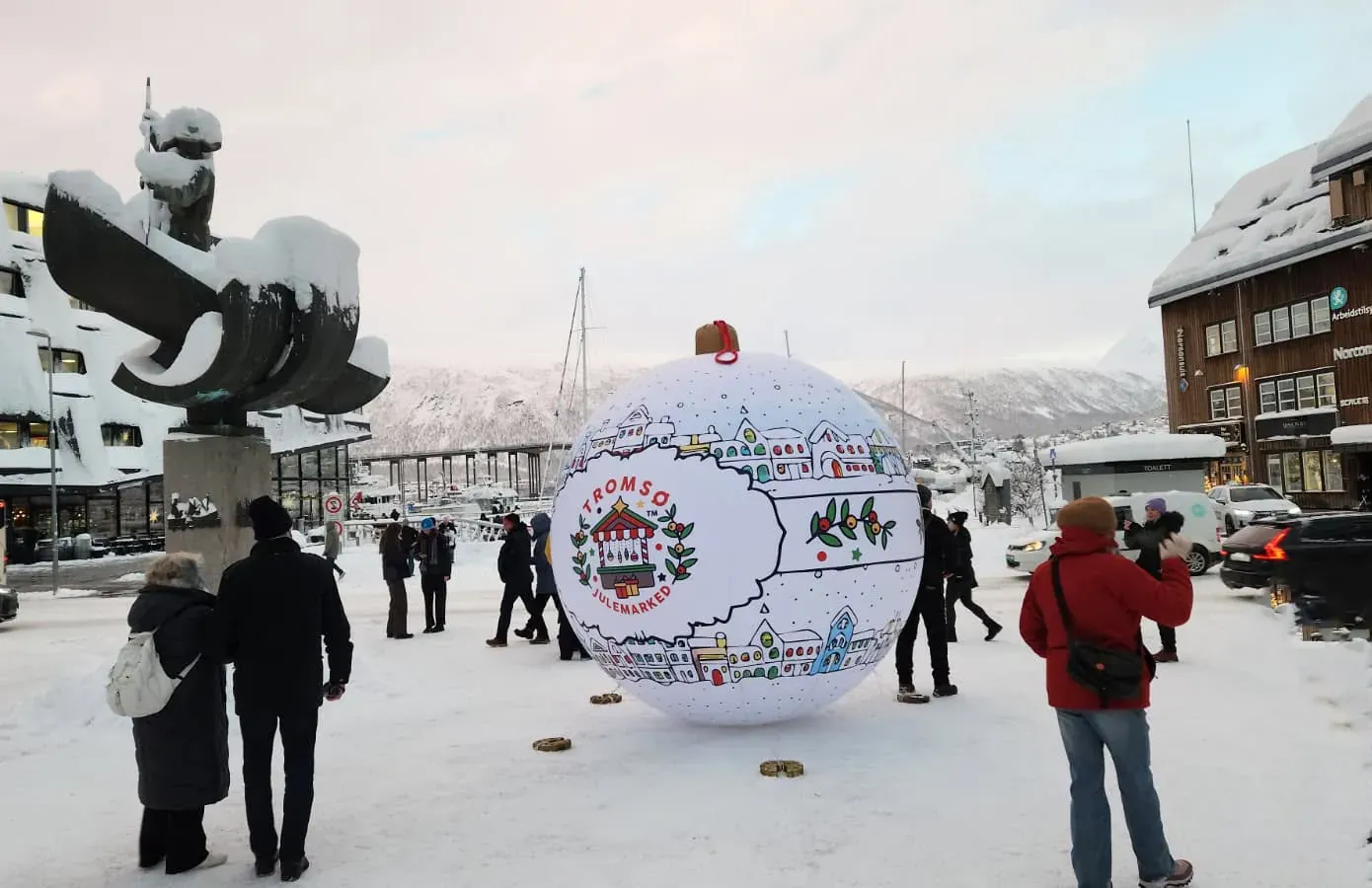 Boule publicitaire sur la place de Tromsø Grande boule de Noël à air captif sur une place enneigée de Tromsø, avec la ville en arrière-plan.