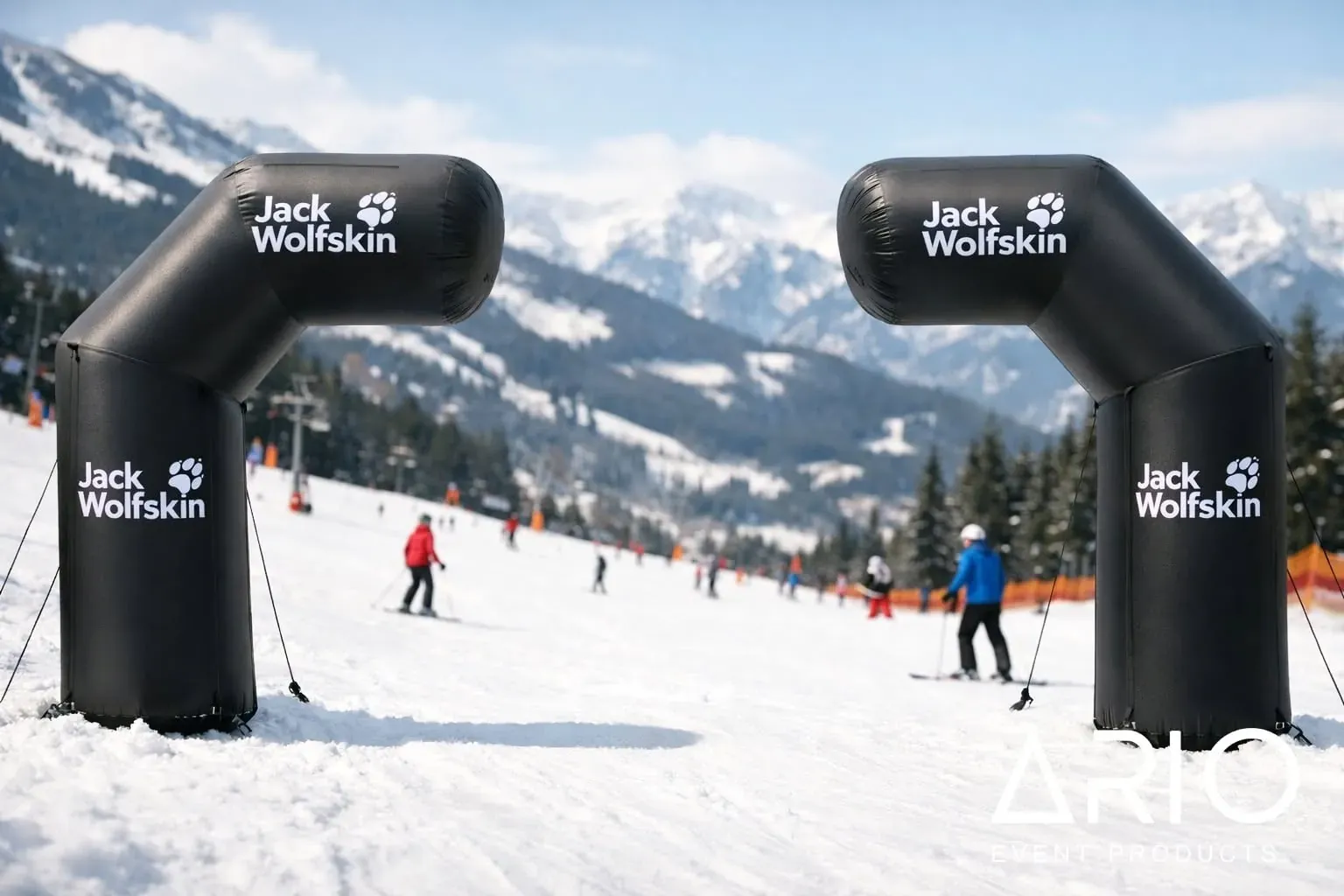 Deux arches gonflables Jack Wolfskin sur la piste Deux arches gonflables noires au logo blanc Jack Wolfskin installées sur une piste enneigée.