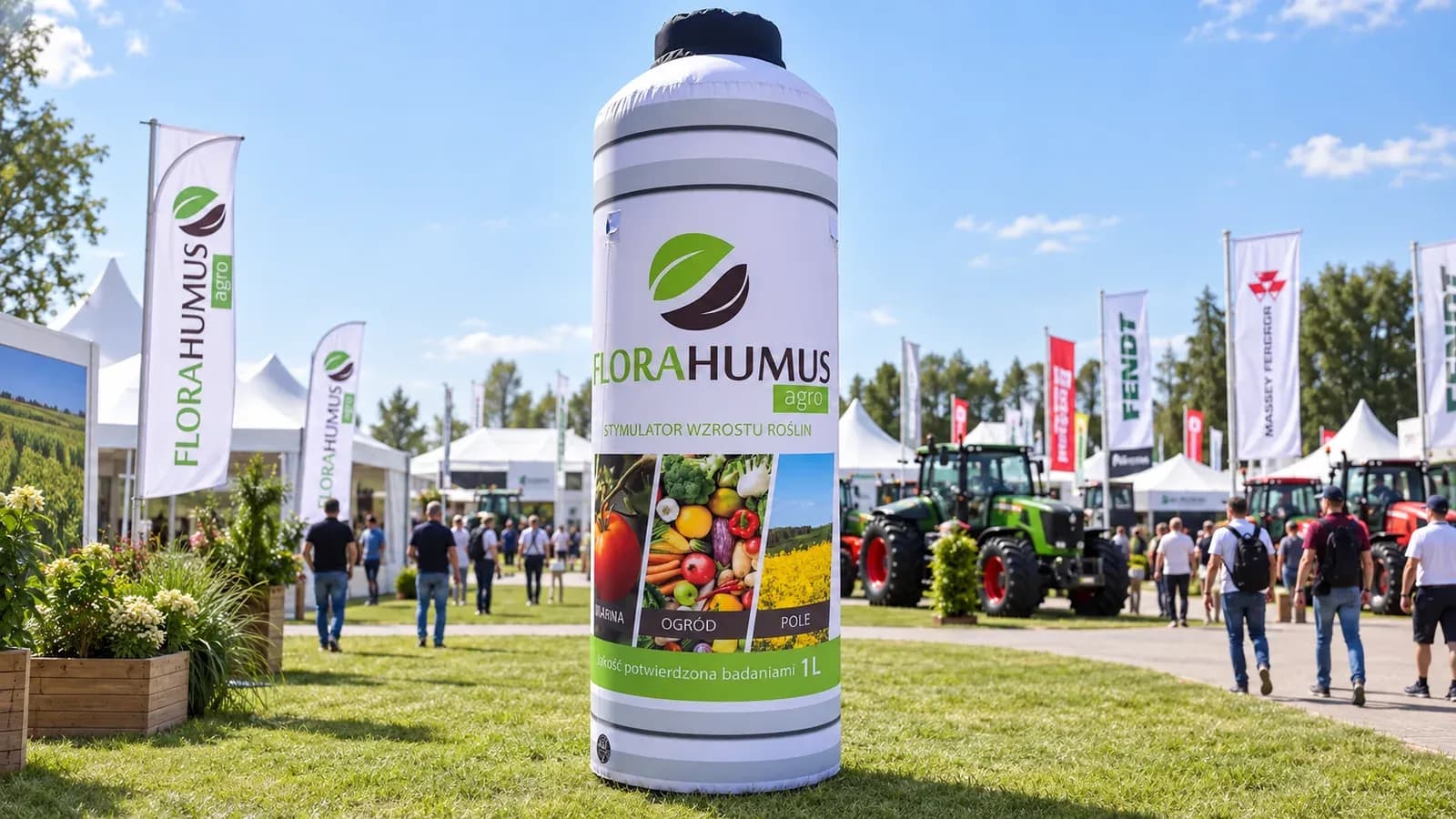 Aufblasbare Werbeflasche auf einer Landwirtschaftsmesse, im Hintergrund Traktoren und Ausstellerfahnen.