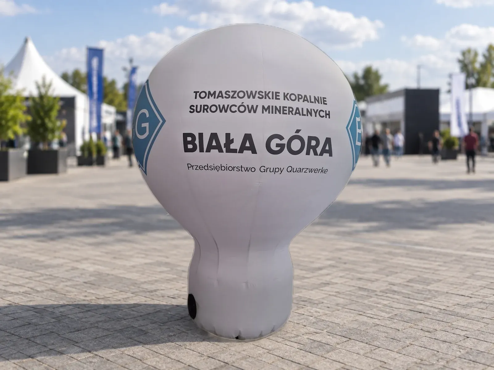 Balon reklamowy pneumatyczny z nadrukiem w barwach marki BG – produkt ARIO, tło wygenerowane przez AI