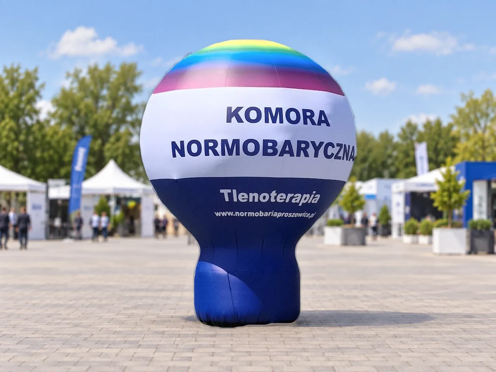 Balon reklamowy pneumatyczny z nadrukiem w barwach marki Komora Normobaryczna – produkt ARIO, tło wygenerowane przez AI