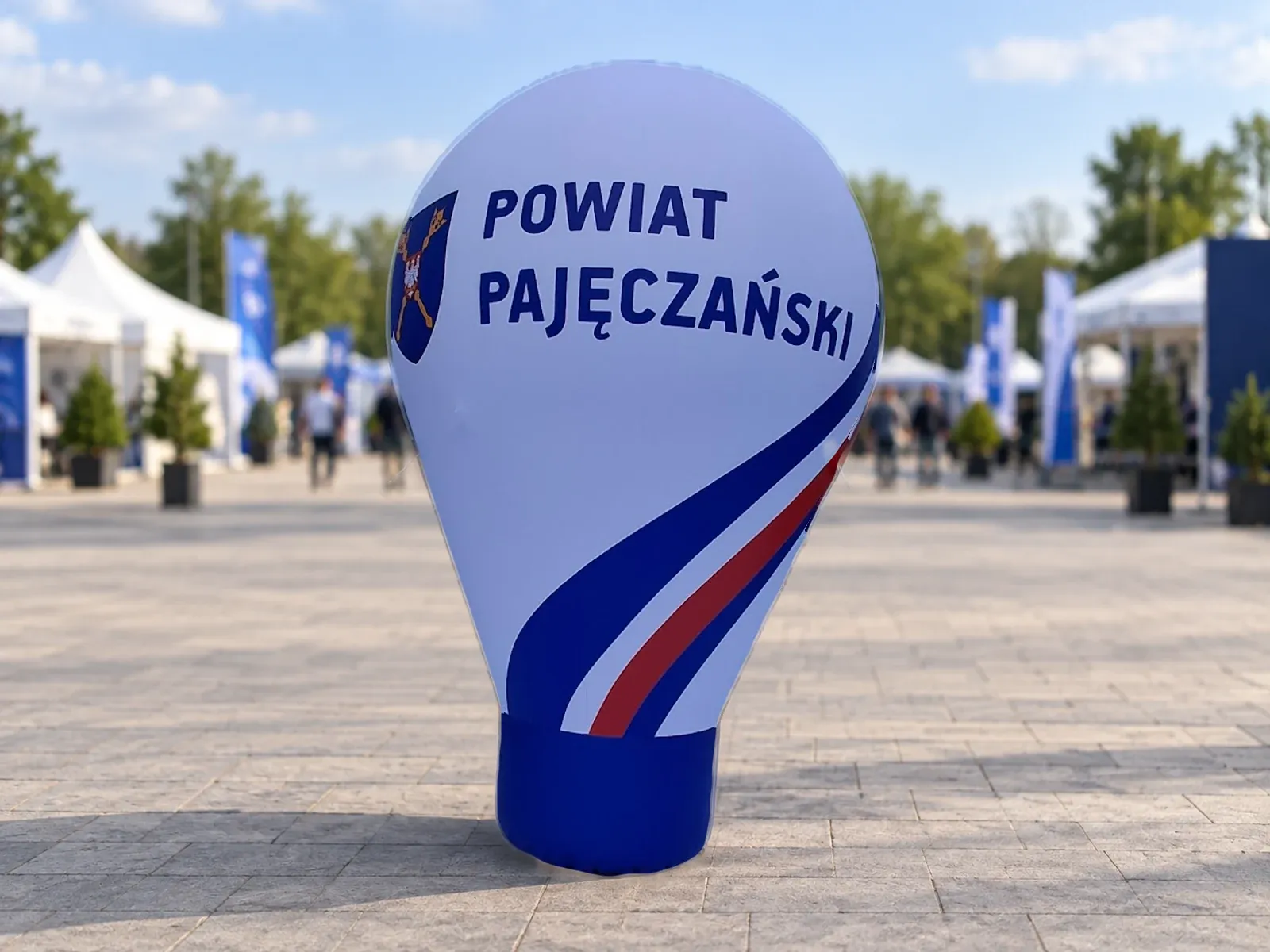 Advertising balloon for Powiat Pajęczański Balon reklamowy pneumatyczny z nadrukiem w barwach marki Powiat Pajęczański – produkt ARIO, tło wygenerowane przez AI