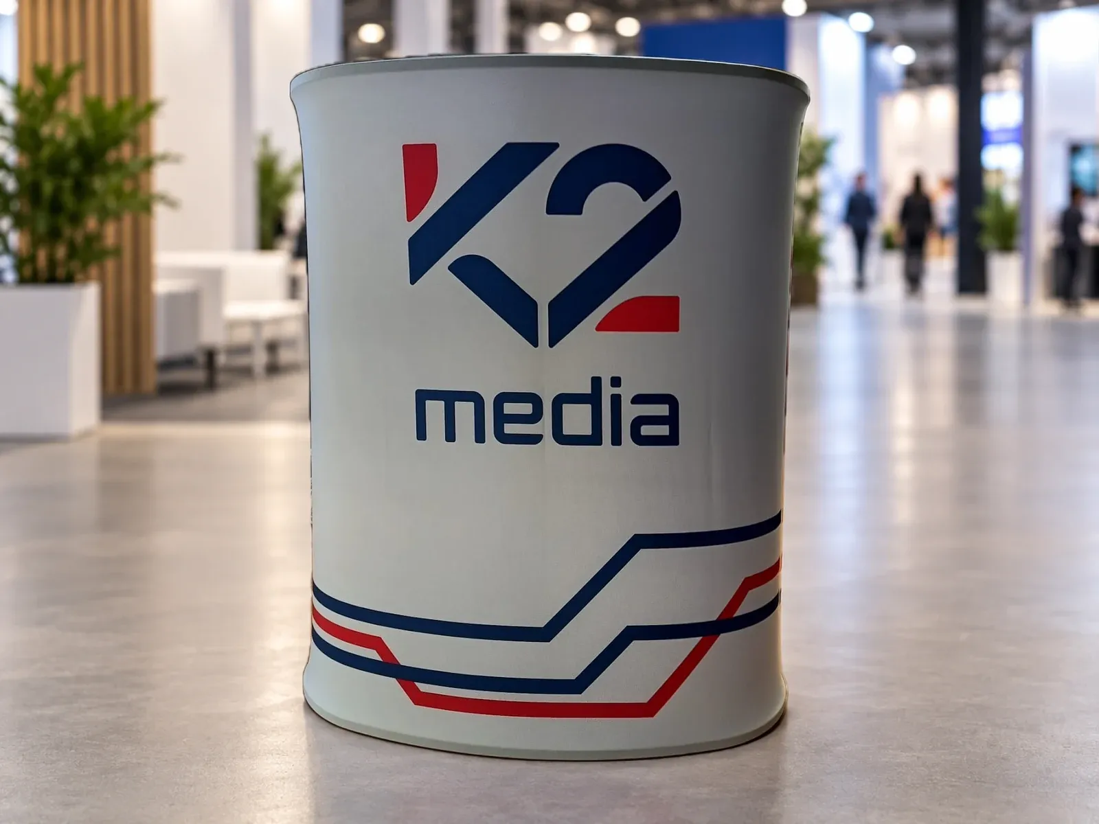Promo pult pro K2 media Trybunka reklamowa z nadrukiem w barwach marki K2 media – produkt ARIO, tło wygenerowane przez AI