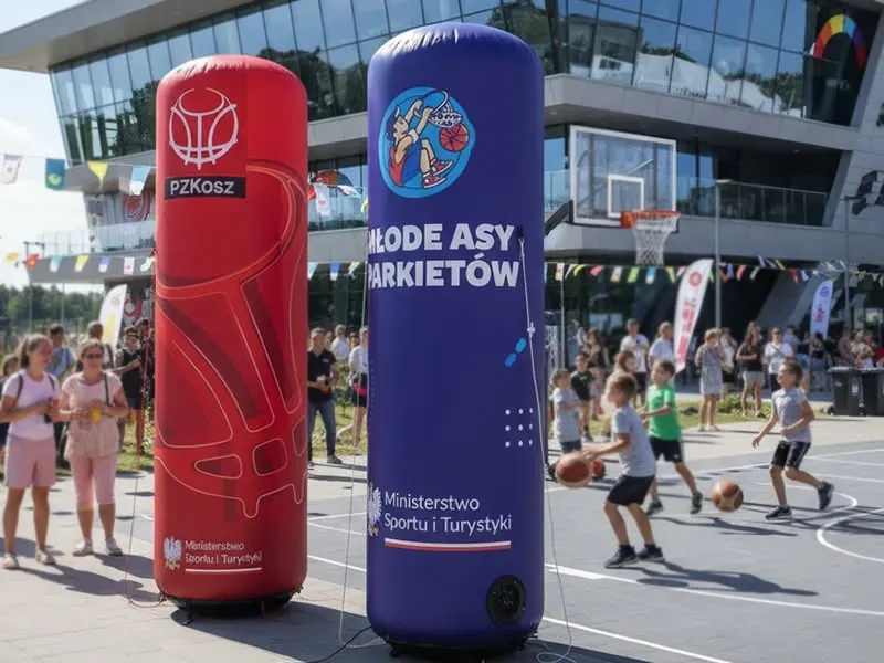 Dwa słupy pneumatyczne z logotypami organizatorów przy boisku do koszykówki 3x3.
